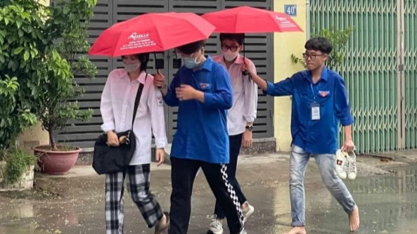 Tình nguyện viên Thủ đô “đầu trần” hứng mưa, nhường ô cho các thí sinh