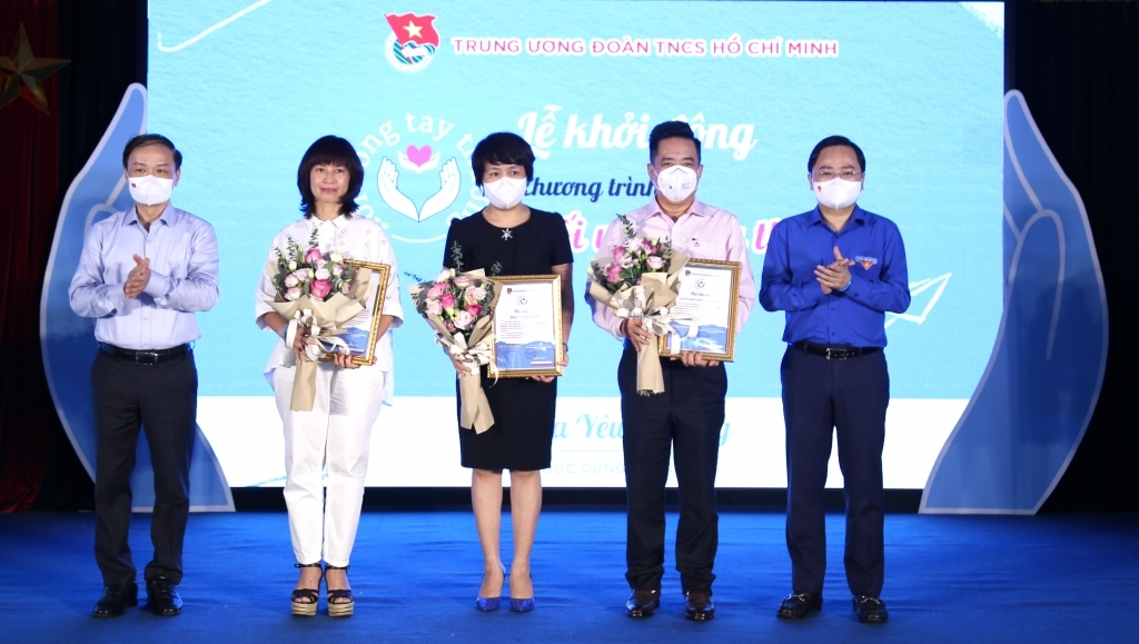 Đồng chí Phạm Tất Thắng, Ủy viên BCH Trung ương Đảng, Phó trưởng Ban Thường trực Ban Dân vận Trung ương và đồng chí Nguyễn Anh Tuấn, Ủy viên BCH Trung ương Đảng, Bí thư Thứ nhất Trung ương Đoàn trao giấy chứng nhận, tặng hoa cảm ơn các đơn vị đồng hành
