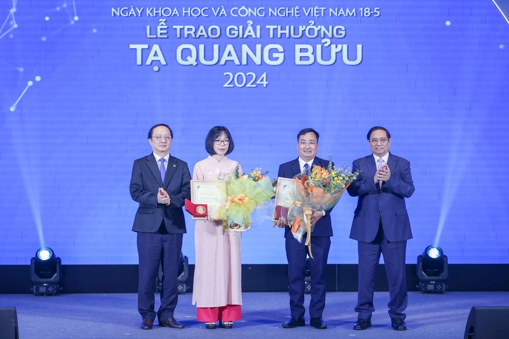 Thủ tướng Phạm Minh Chính và Bộ trưởng KH&CN Huỳnh Thành Đạt trao Giải thưởng Tạ Quang Bửu, tặng hoa chúc mừng PGS.TS Trần Mạnh Trí và TS. Nguyễn Thị Kim Thanh - Ảnh: VGP/Nhật Bắc