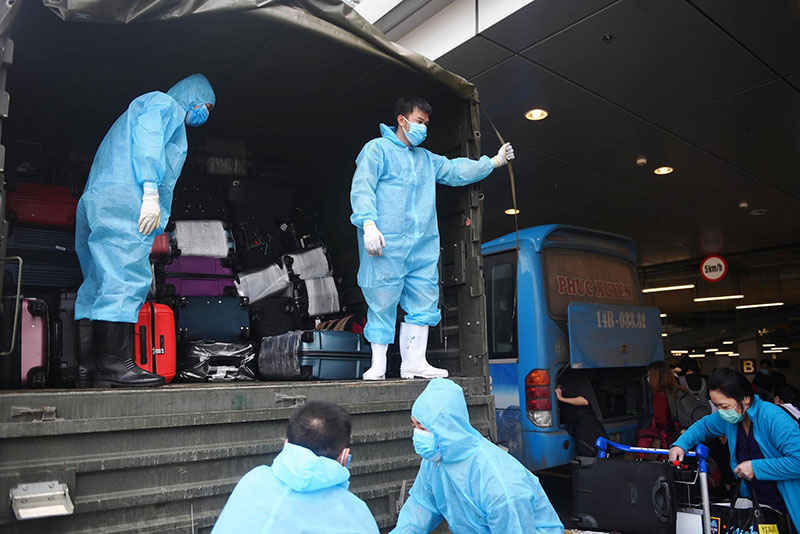 CBNV sb Vân Đồn hỗ trợ xếp hành lý của hành khách lên xe chuyên chở về khu cách ly.