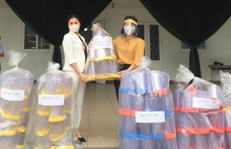 Những chiếc mũ cản giọt bắn được chị L&ecirc; Thị Hồng Hạnh (b&ecirc;n tr&aacute;i) trao tặng tới c&ocirc; tr&ograve; trường Tiểu học Bồ Đề