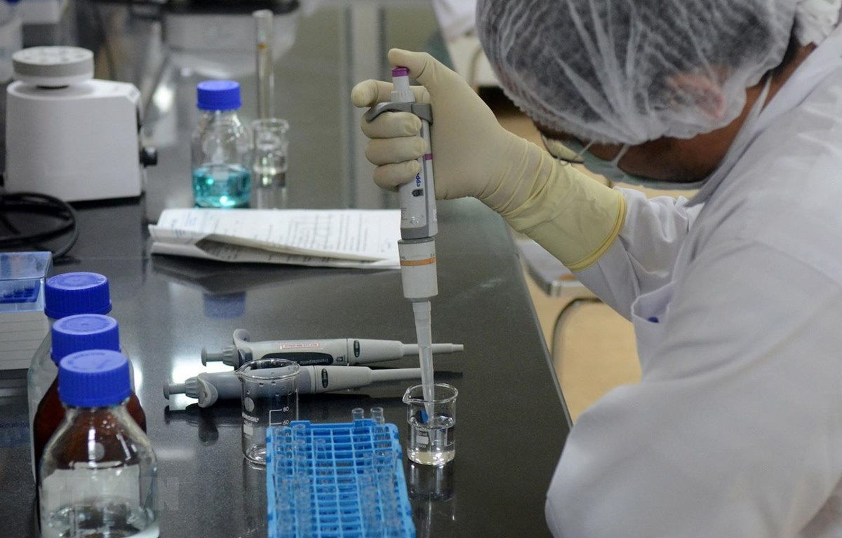 Nghiên cứu viên bào chế vắcxin phòng COVID-19 tại phòng thí nghiệm. (Ảnh: Reuters/TTXVN